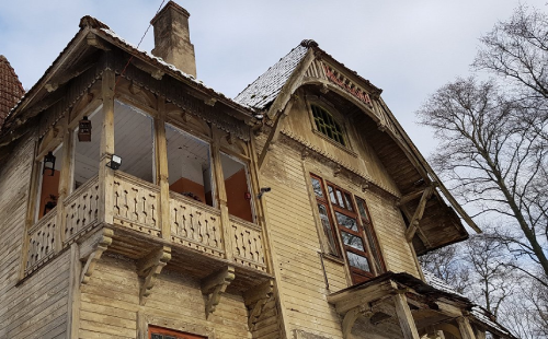 Detail of an ornate weathered wooden house facade in Riga