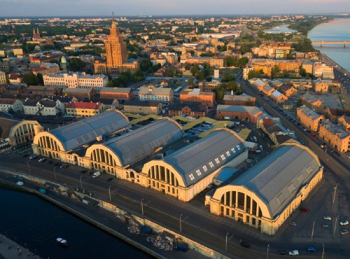 Aerial view of Riga Central Market pavilions and city skyline at golden hour